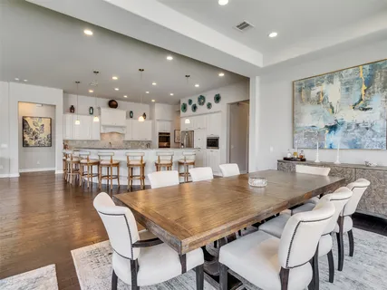 a dining room with stainless steel appliances a table and chairs
