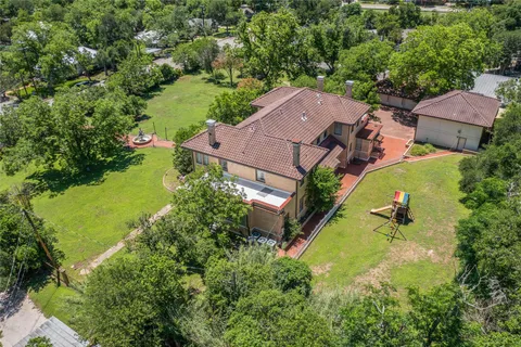 an aerial view of a house with outdoor space and a lake view