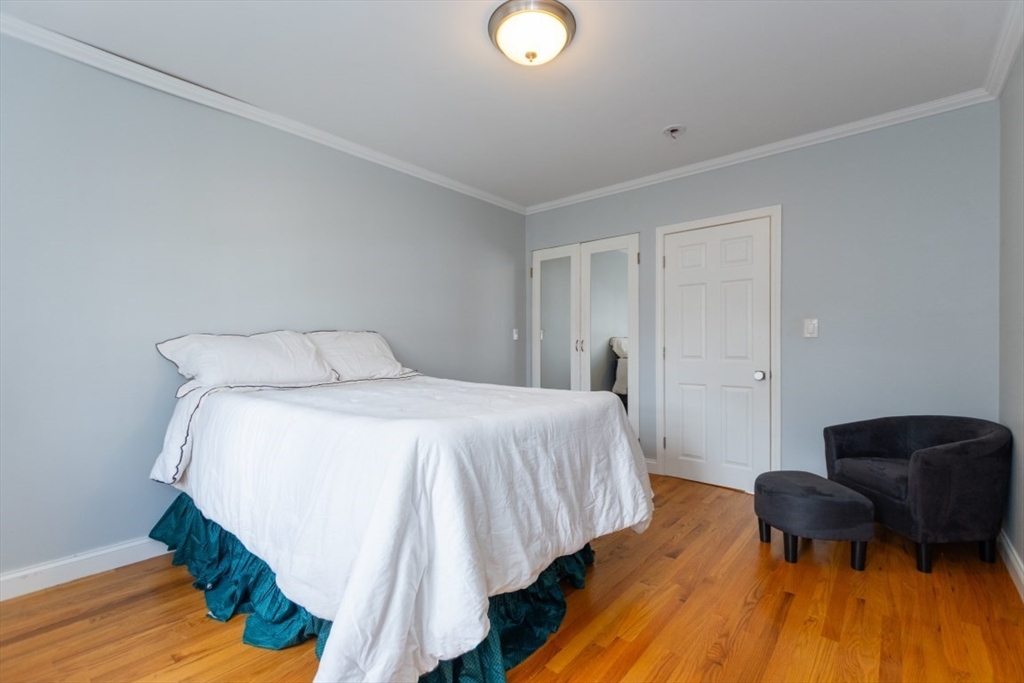 121 Lake Shore Road, Unit 2 Boston, MA 02135 - Photo 15 of 32 a bedroom with a bed and wooden floor