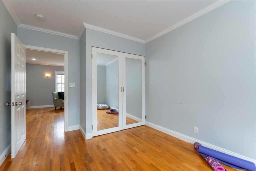 121 Lake Shore Road, Unit 2 Boston, MA 02135 - Photo 19 of 32 a view of a hallway with wooden floor and a bathroom