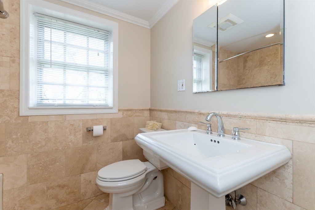 121 Lake Shore Road, Unit 2 Boston, MA 02135 - Photo 20 of 32 a bathroom with a sink a toilet and a mirror