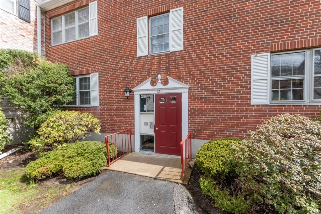 121 Lake Shore Road, Unit 2 Boston, MA 02135 - Photo 27 of 32 front view of a brick house with a yard