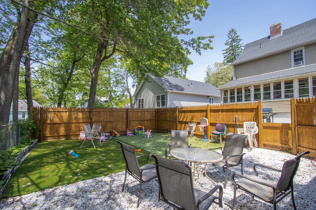 34 Preston Street Springfield, MA 01109 - Photo 32 of 34 a view of a patio with table and chairs potted plants and wooden fence