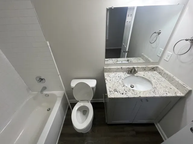 a bathroom with a granite countertop sink toilet and shower