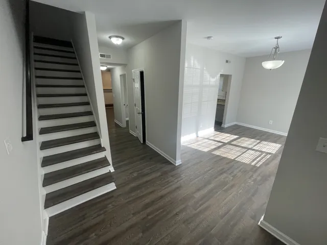 an empty room with wooden floor and windows