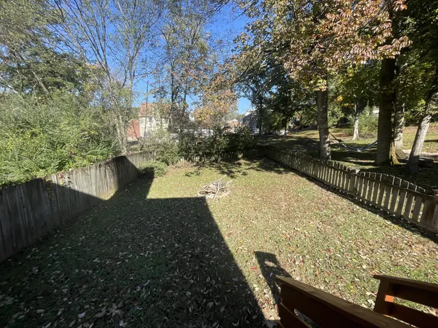 a view of a backyard with wooden fence