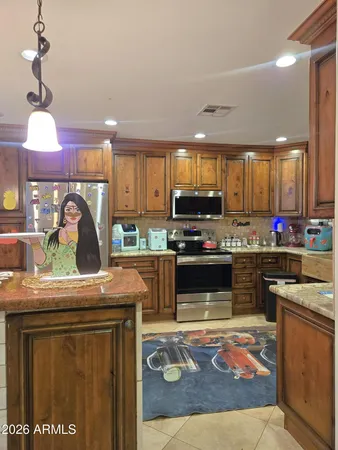 a view of a kitchen with kitchen island and stainless steel appliances