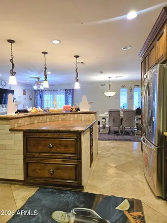 a kitchen with stainless steel appliances granite countertop a refrigerator a stove and a sink with wooden floors