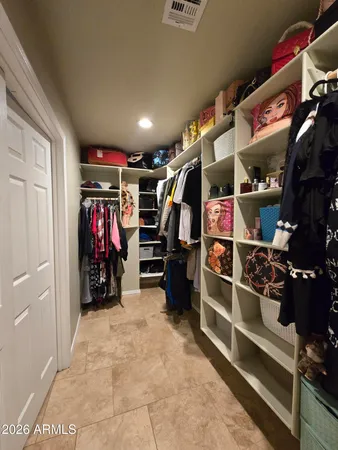 a view of walk in closet with clothes and shoes