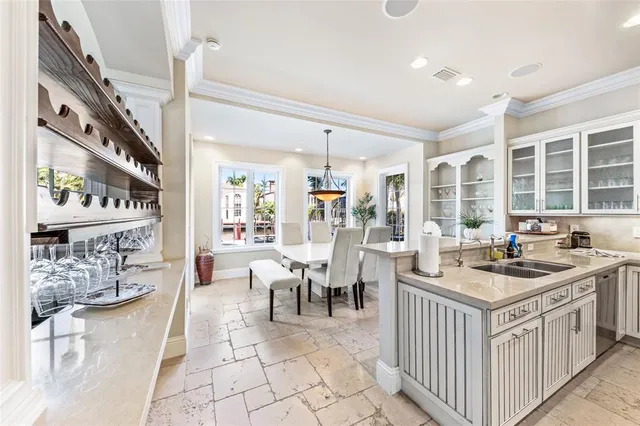 a kitchen that has a lot of white cabinets and couches