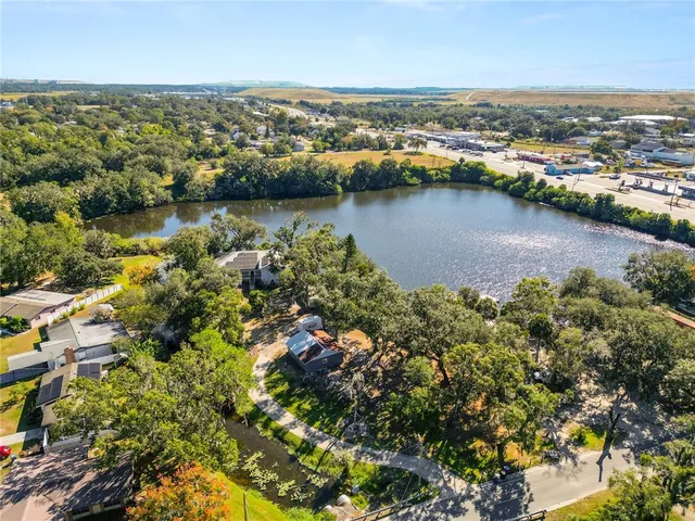 an aerial view of residential houses with outdoor space and lake view
