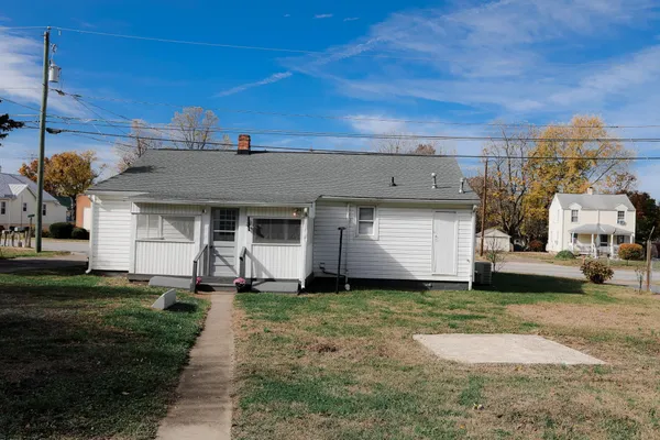 a view of a house with a yard and a large tree