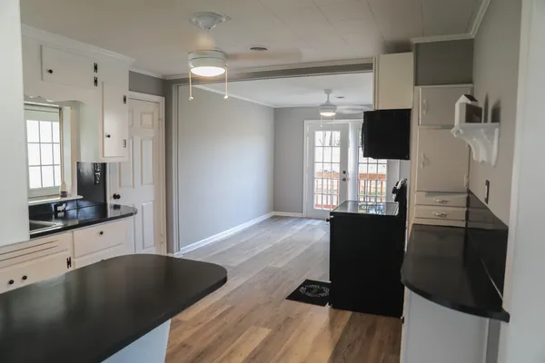 a living room with stainless steel appliances furniture and a flat screen tv
