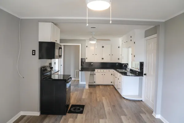 an empty room with wooden floor and a hallway