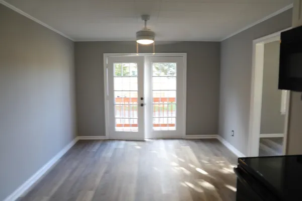 an empty room with wooden floor and windows