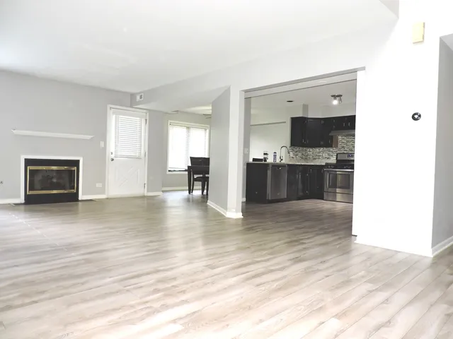 a living room with stainless steel appliances kitchen island granite countertop a stove and a refrigerator