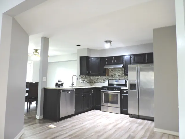 a kitchen with stainless steel appliances granite countertop a sink stove and refrigerator