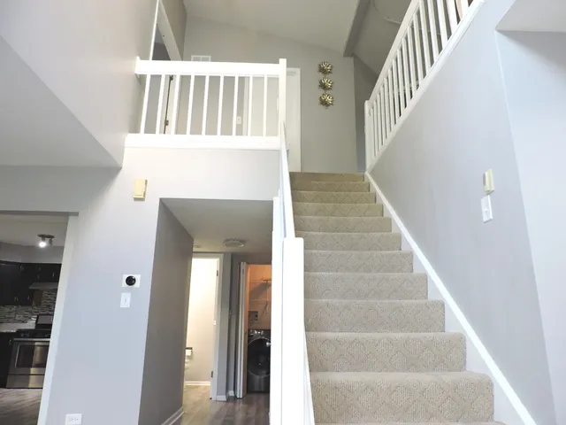 a view of staircase with white walls and windows