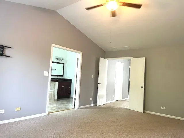 an empty room with a window and chandelier fan
