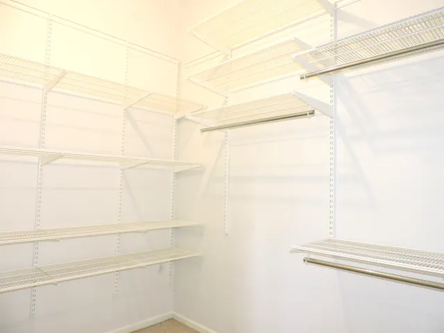 a view of walk in closet with empty racks