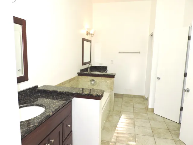 a bathroom with a granite countertop sink and a toilet