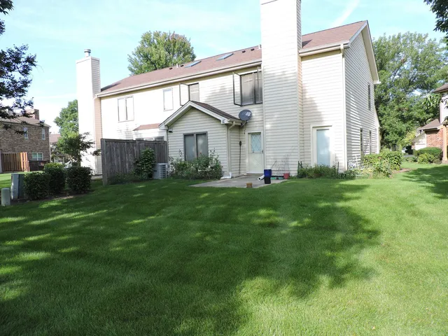 a front view of a house with a yard and trees