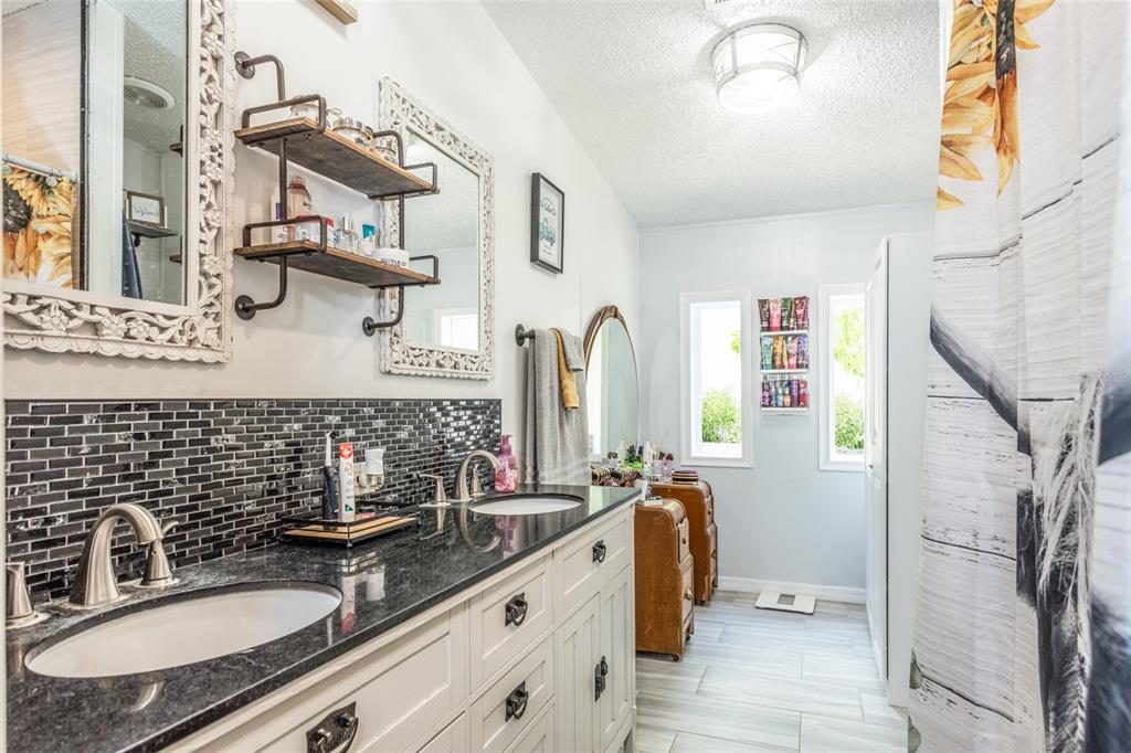 1013 Forest Park Street Bunnell, FL 32110 - Photo 14 of 24 a bathroom with double vanity sink a mirror and a shower