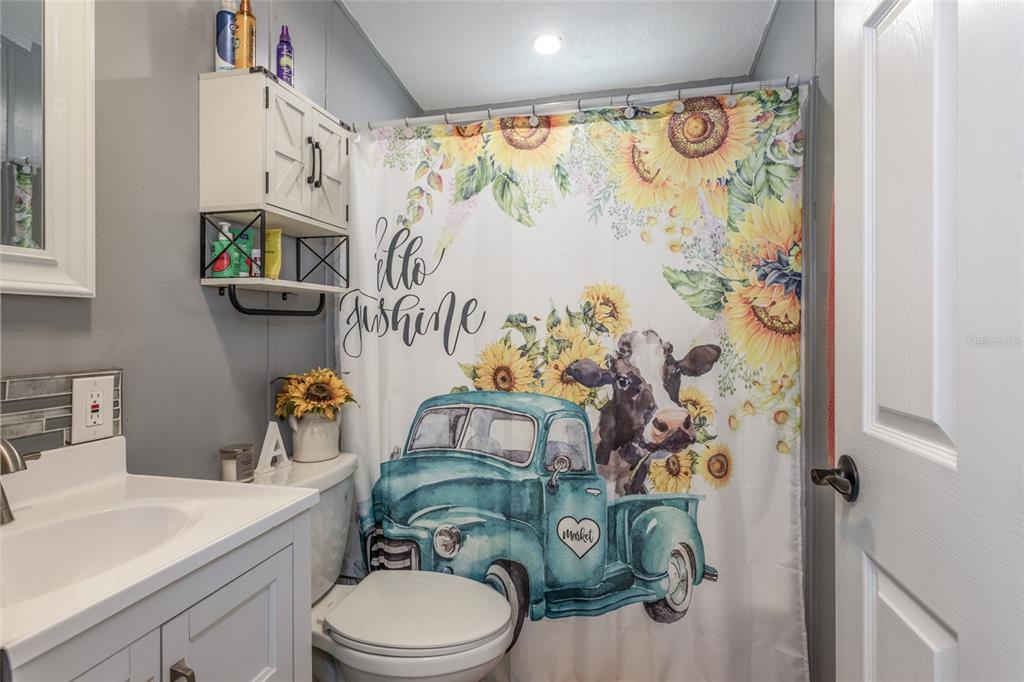 1013 Forest Park Street Bunnell, FL 32110 - Photo 17 of 24 a bathroom with a sink a toilet and shower curtain