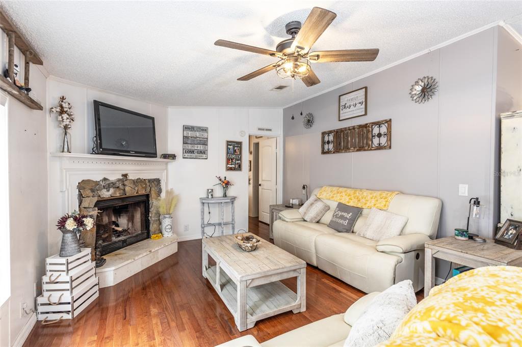 1013 Forest Park Street Bunnell, FL 32110 - Photo 4 of 24 a living room with furniture a flat screen tv and a fireplace