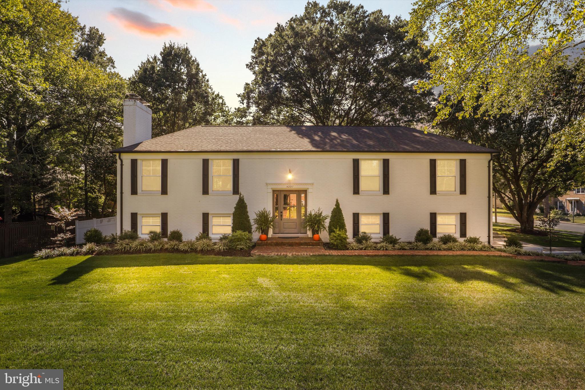 a front view of a house with swimming pool and trees