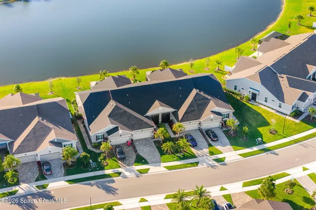 a view of a white house next to a yard and trees
