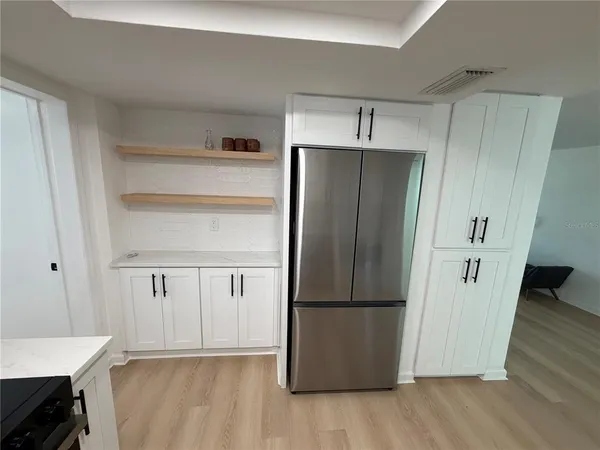 a room with stainless steel appliances wooden floor and staircase