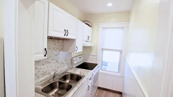 a kitchen with a white stove top oven and refrigerator