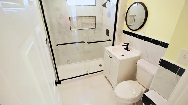 a white toilet sitting next to a bathroom sink