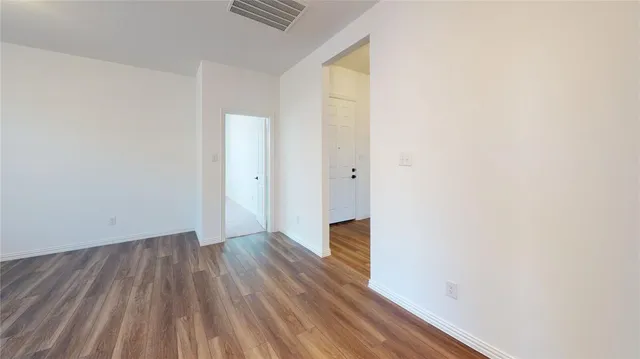a view of a room with wooden floor and a window