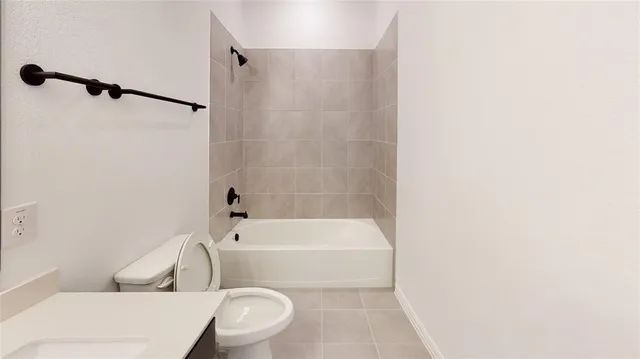 a white toilet and tub sitting next to a bathroom sink