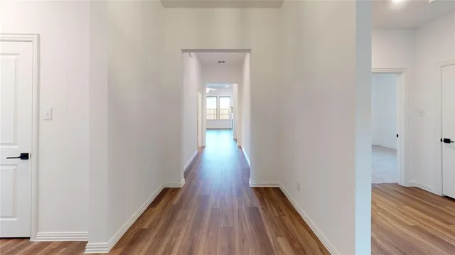 a view of a hallway with wooden floor