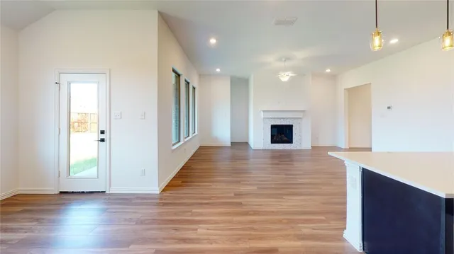 an empty room with wooden floor and fireplace