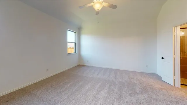 an empty room with a window and a chandelier fan