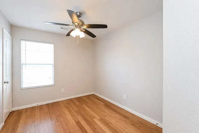 an empty room with a window and wooden floor