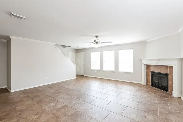 an empty room with windows and fireplace