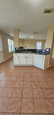 a large kitchen with stainless steel appliances a sink dishwasher stove and cabinets