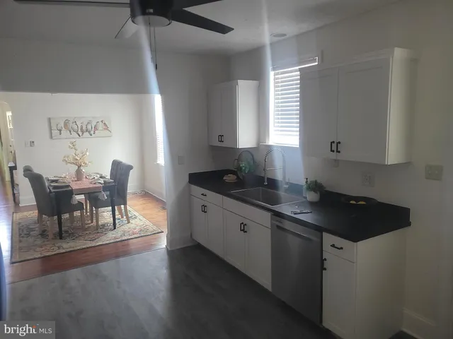 a kitchen with granite countertop sink cabinets and wooden floor