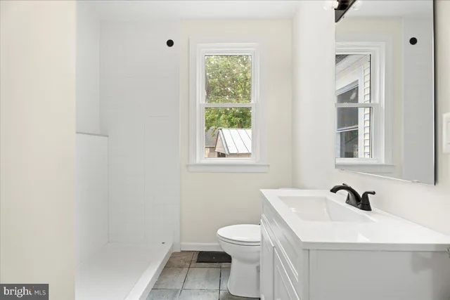 a bathroom with a sink a toilet and a window