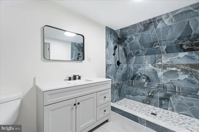 a bathroom with a sink mirror and a toilet