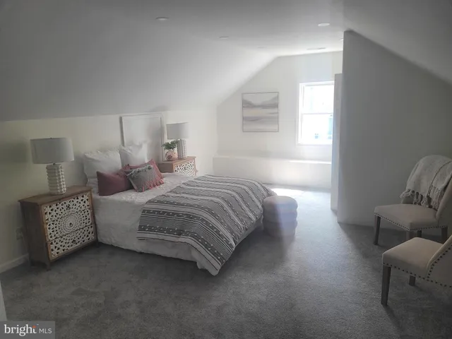 a bedroom with bed couch and window