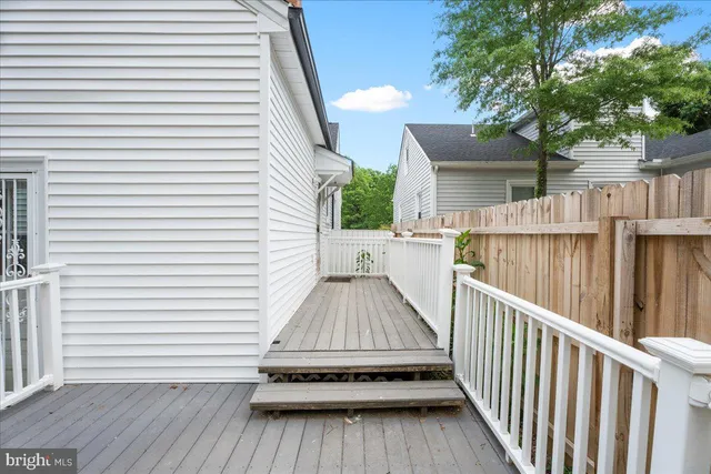 a view of backyard with small deck and wooden floor