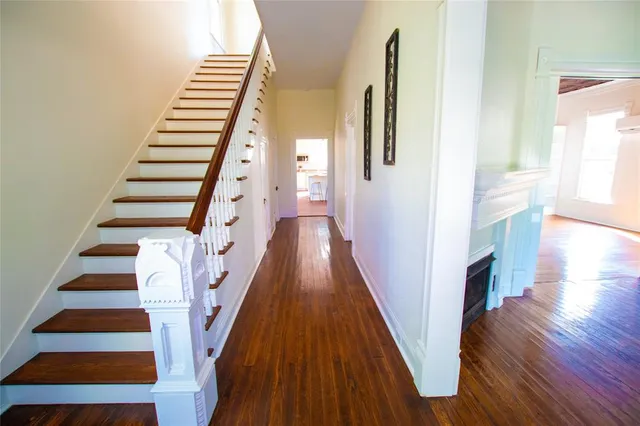 a view of a hallway with wooden floor and staircase