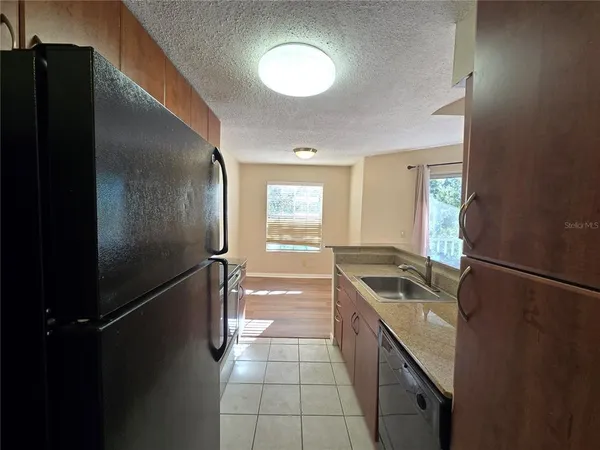 a kitchen with granite countertop a refrigerator and a sink