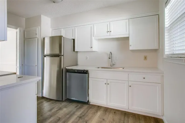 a kitchen with a refrigerator sink and cabinets